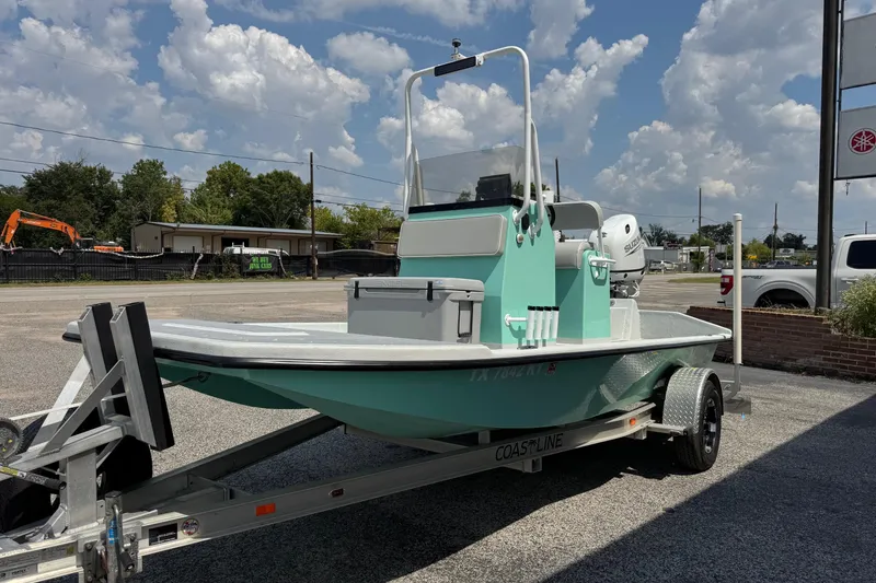Slide: The Image of 2025 Mowdy 16 Cat boat on trailer, parked outdoors under a cloudy sky. - 2
