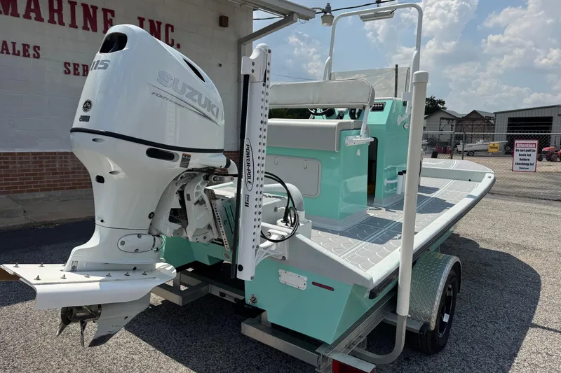 Slide: The Image of 2025 Mowdy 16 Cat boat with Suzuki outboard motor, parked outdoors. - 4