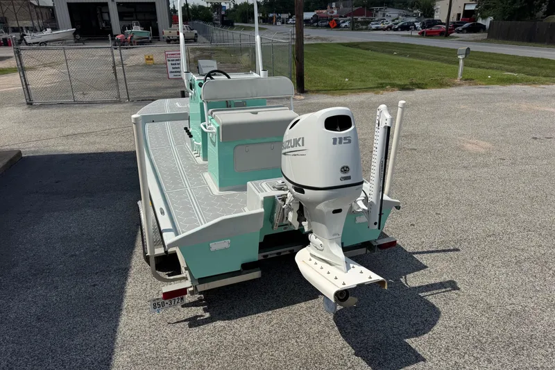 Slide: The Image of 2025 Mowdy 16 Cat boat with Suzuki 115 outboard motor in a parking lot. - 5