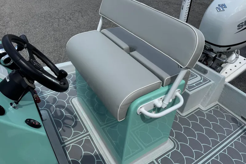 Slide: The Image of 2025 Mowdy 16 Cat boat interior with steering wheel and cushioned seating. - 7