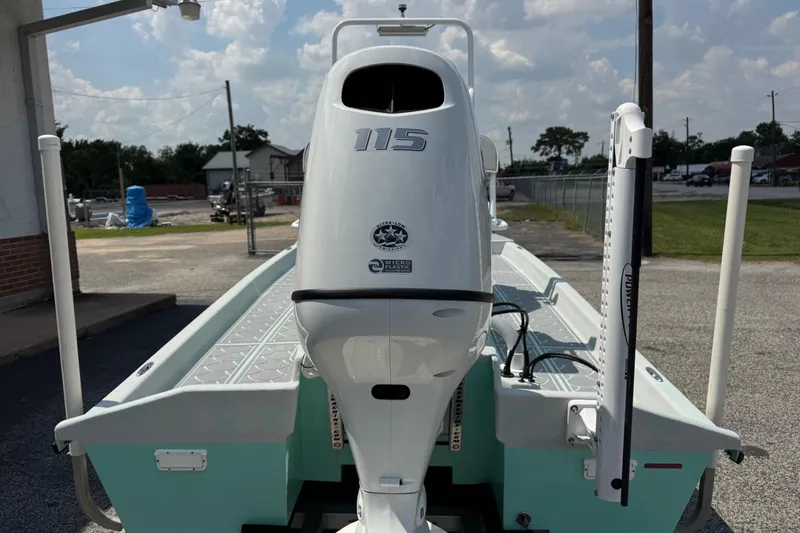 Slide: The Image of 2025 Mowdy 16 Cat boat with powerful outboard motor, parked outdoors. - 8