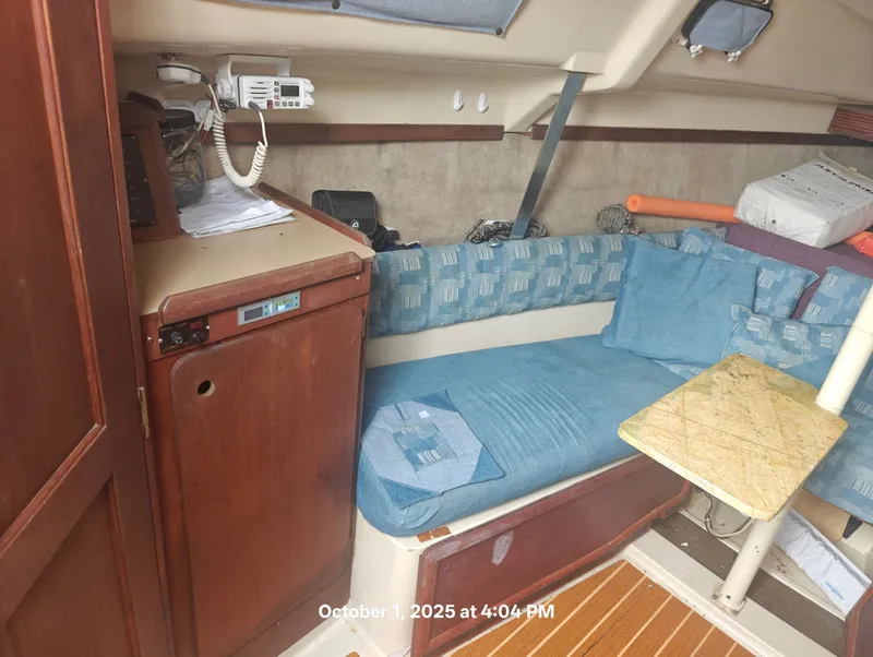 Slide: The Image of Interior of 1990 Hunter 27-2 sailboat with blue seating and wooden cabinetry. - 19