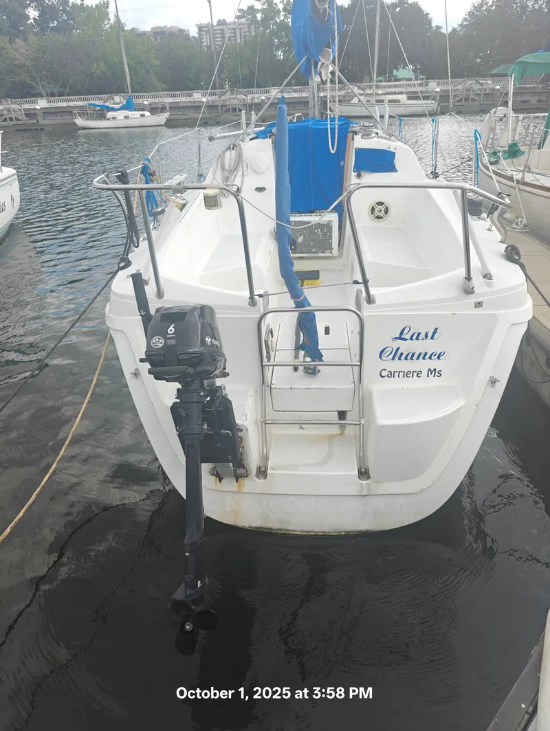 Slide: The Image of Hunter 27-2 sailboat docked, rear view, with outboard motor, named "Last Chance," dated October 1, 2025. - 2