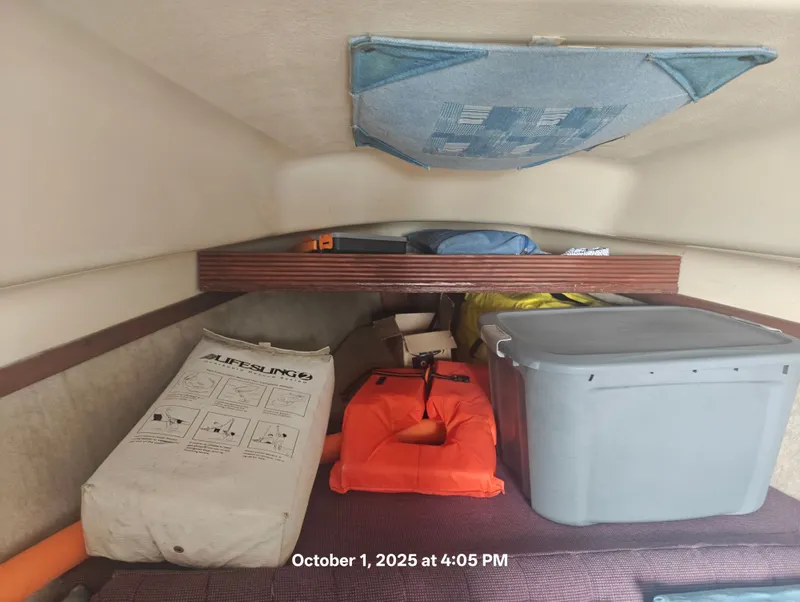Slide: The Image of Storage area in a 1990 Hunter 27-2 sailboat with safety equipment and supplies. - 22