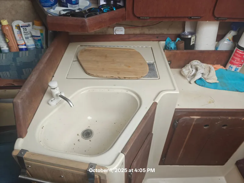 Slide: The Image of Small kitchen area in a 1990 Hunter 27-2 sailboat with sink and countertop. - 25