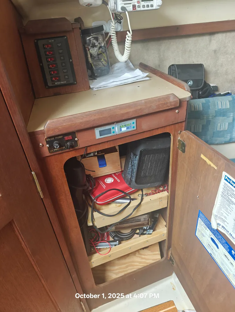 Slide: The Image of Interior of a 1990 Hunter 27-2 sailboat showing electrical panel and storage shelves. - 26