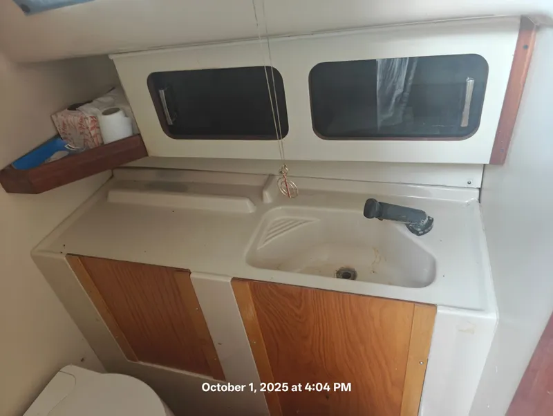 Slide: The Image of Interior of a 1990 Hunter 27-2 sailboat showing a compact sink and storage area. - 35