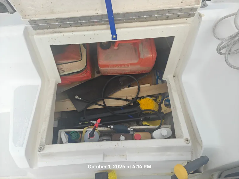 Slide: The Image of Open storage compartment on a 1990 Hunter 27-2 sailboat with various tools and supplies. - 36