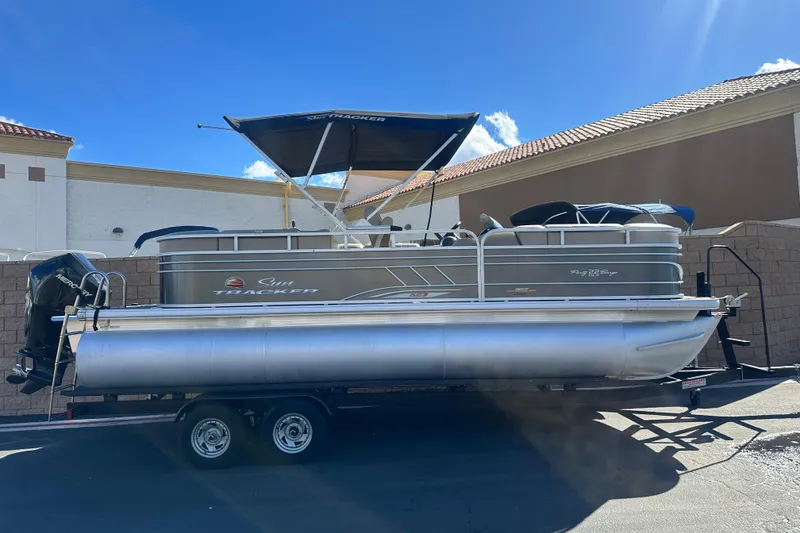 The Image of 2023 Sun Tracker Party Barge 22 RF XP3 pontoon boat on trailer, parked outdoors. - 0