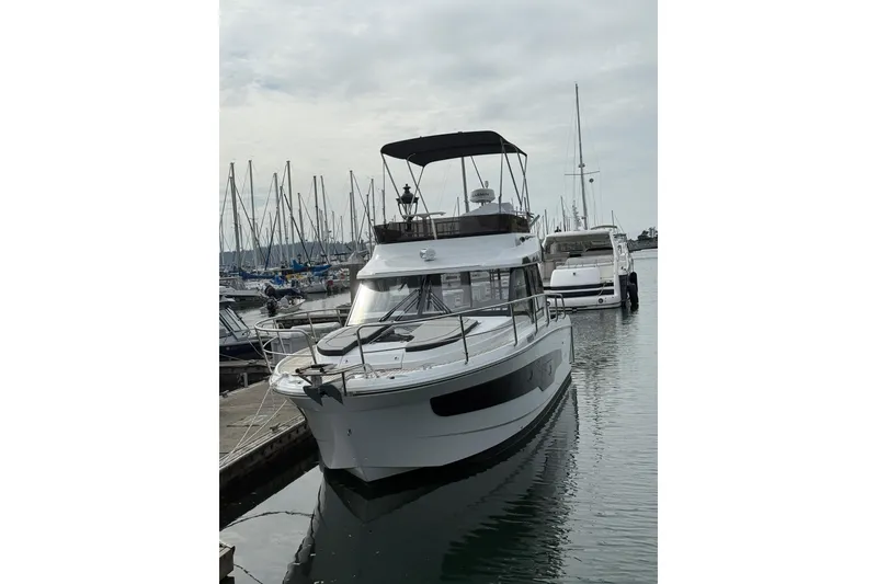 Slide: The Image of 2025 Jeanneau NC 1095 Fly yacht docked in marina, overcast sky. - 19