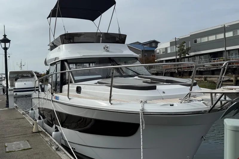 Slide: The Image of 2025 Jeanneau NC 1095 Fly yacht docked at marina, showcasing sleek design and modern features. - 20