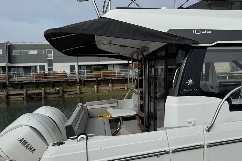 Slide: The Image of 2025 Jeanneau NC 1095 Fly yacht docked, featuring Yamaha engines and modern design. - 22