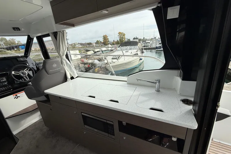 Slide: The Image of Interior of 2025 Jeanneau NC 1095 Fly boat with modern kitchen and steering area. - 27