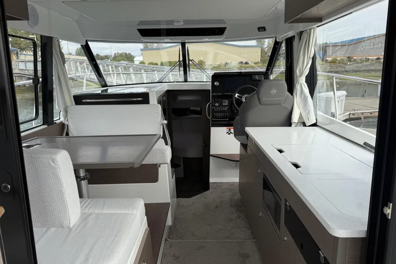 Slide: The Image of Interior of 2025 Jeanneau NC 1095 Fly boat, featuring modern seating and navigation area. - 29