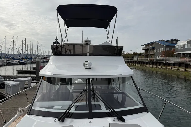 Slide: The Image of 2025 Jeanneau NC 1095 Fly yacht docked at marina, overcast sky. - 36