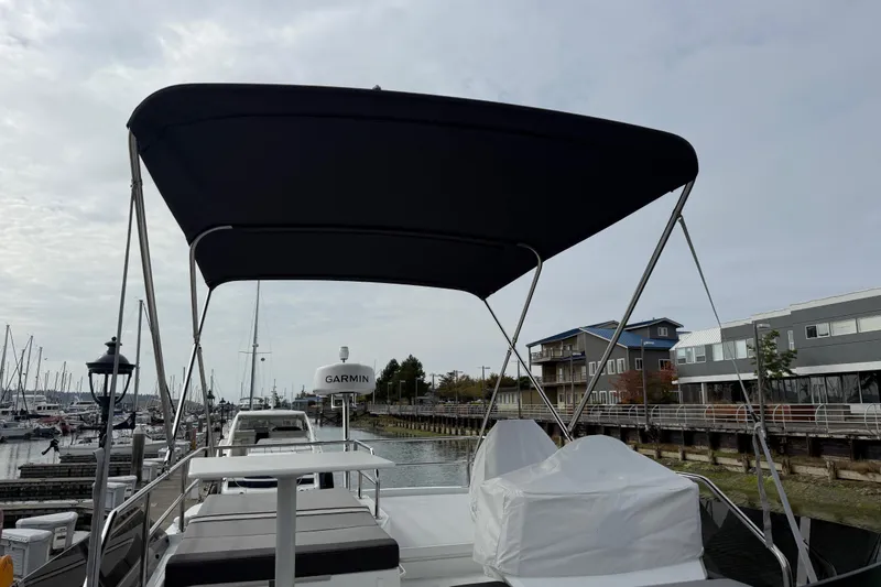 Slide: The Image of 2025 Jeanneau NC 1095 Fly yacht docked at marina with covered seating area. - 37