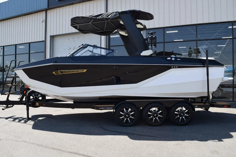 The Image of 2025 Nautique Super Air Nautique G23 boat on trailer, black and white design. - 0