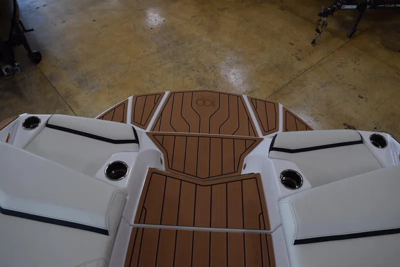 Slide: The Image of 2025 Nautique Super Air Nautique G23 boat deck with teak-style flooring and cup holders. - 10