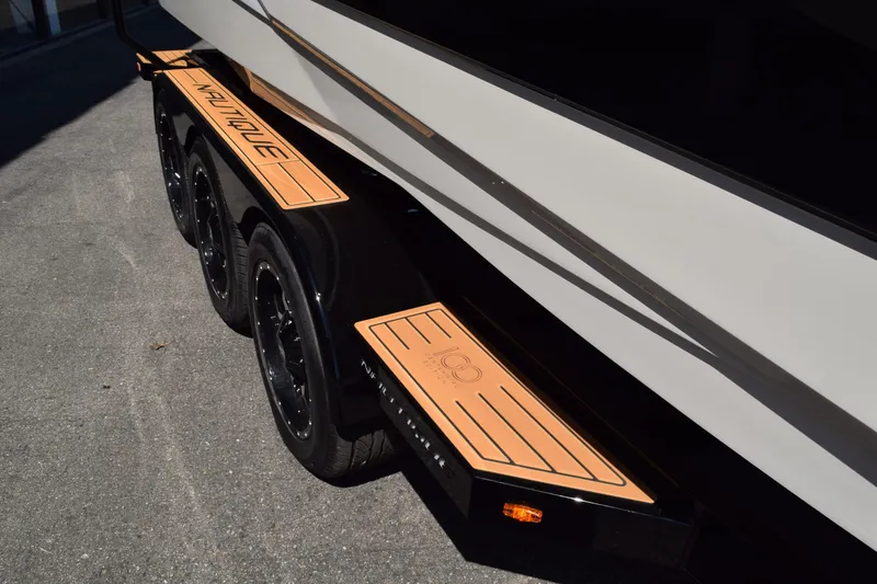 Slide: The Image of 2025 Nautique Super Air Nautique G23 trailer with custom orange accents and black wheels. - 3