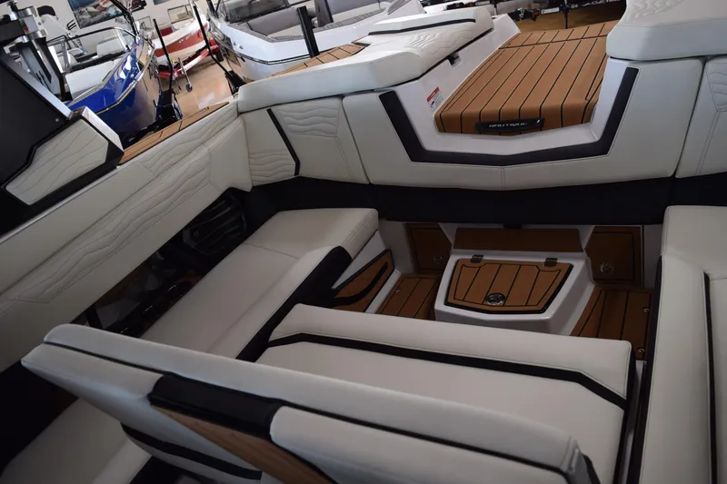 Slide: The Image of 2025 Nautique Super Air Nautique G23 interior with luxurious seating and teak flooring. - 7