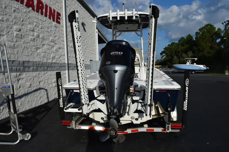 Slide: The Image of 2021 Sportsman Tournament 234 Bay Boat with powerful outboard motor, parked near a marine facility. - 5