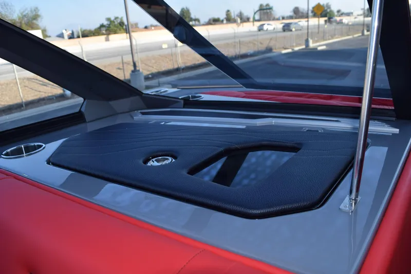 Slide: The Image of 2025 Nautique Super Air Nautique G23 interior with red and black seating, cup holders, and sleek design. - 11