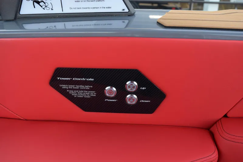 Slide: The Image of 2025 Nautique Super Air Nautique G23 tower controls on red upholstery. - 13