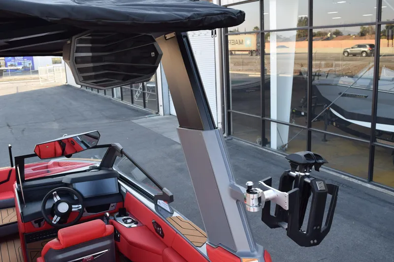 Slide: The Image of 2025 Nautique Super Air Nautique G23 boat interior with red seating and advanced dashboard. - 18