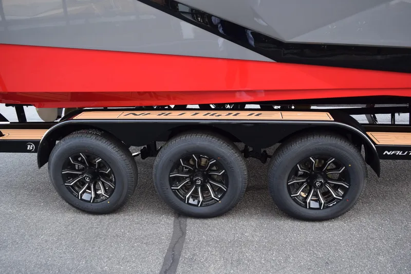 Slide: The Image of 2025 Nautique Super Air Nautique G23 trailer with stylish black wheels and red accents. - 23