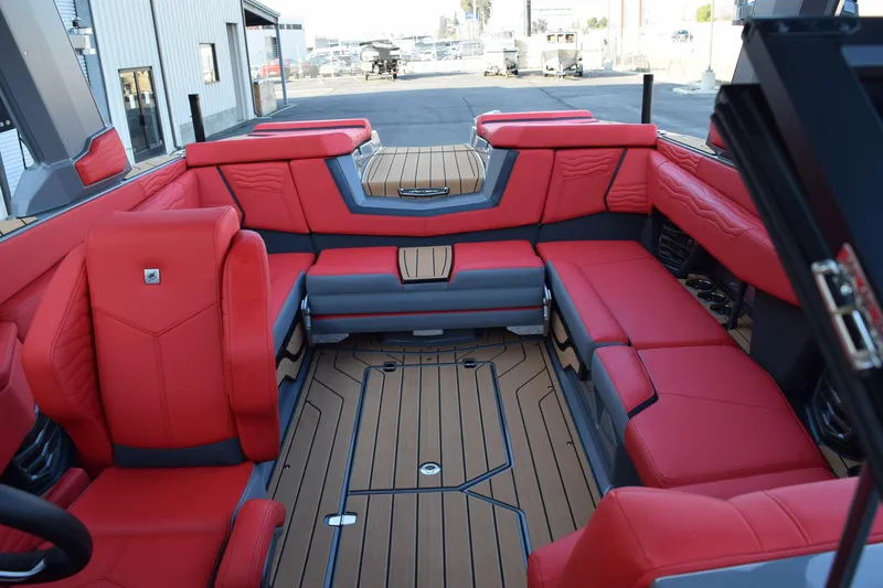 Slide: The Image of 2025 Nautique Super Air Nautique G23 interior with red seating and teak flooring. - 5