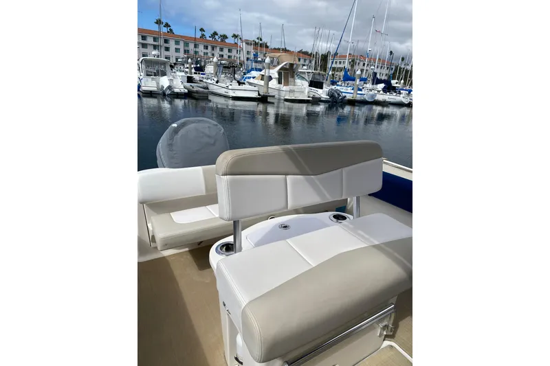 Slide: The Image of 2014 Robalo R222 Center Console boat interior with seating, docked at a marina. - 10