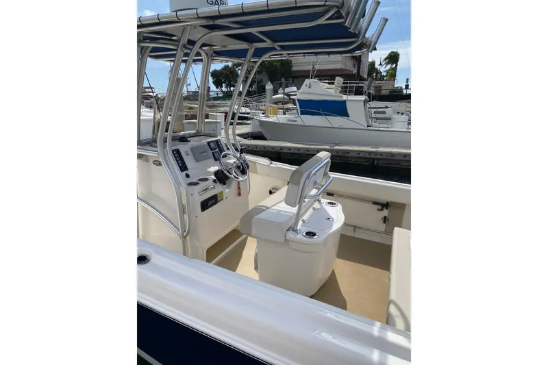 Slide: The Image of 2014 Robalo R222 Center Console boat interior at marina, featuring helm and seating. - 11