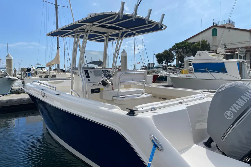 Slide: The Image of 2014 Robalo R222 Center Console boat docked in marina, featuring Yamaha engine. - 2