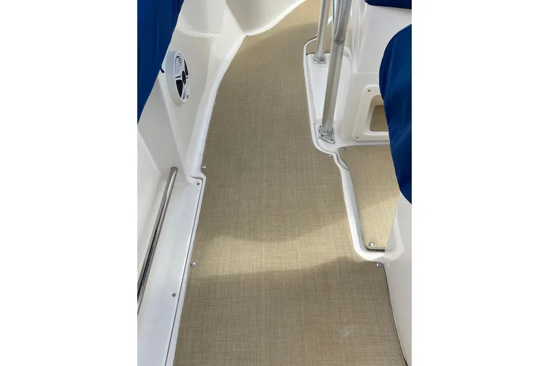Slide: The Image of 2014 Robalo R222 Center Console boat interior with beige flooring and blue seating. - 4