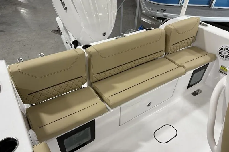 Slide: The Image of 2026 Sportsman Heritage 231 Center Console boat with tan cushioned seating and storage compartments. - 17