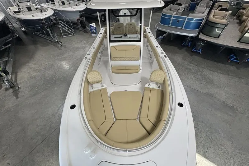 Slide: The Image of 2026 Sportsman Heritage 231 Center Console boat with beige seating in showroom. - 31