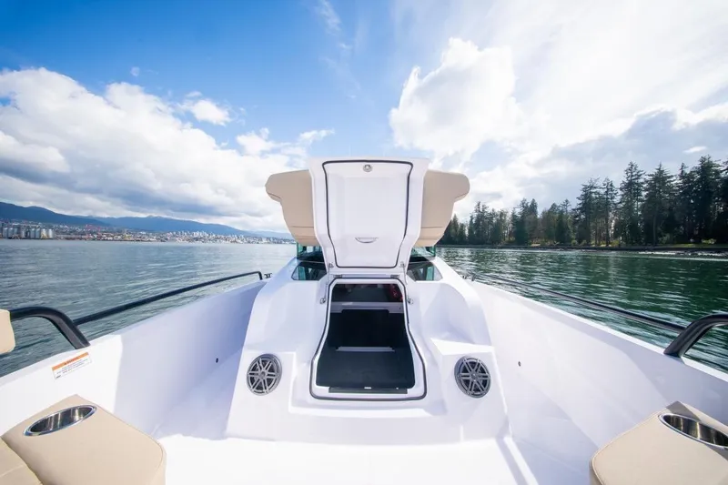 Slide: The Image of 2026 Axopar 29 XC Cross Cabin boat on serene water with open cabin door. - 14