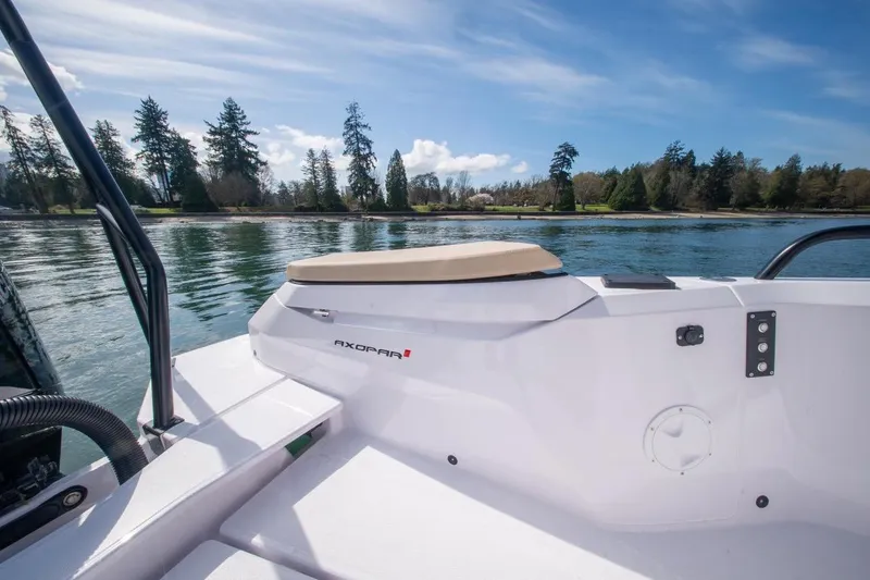 Slide: The Image of 2026 Axopar 29 XC Cross Cabin boat on serene lake with forested shoreline. - 10