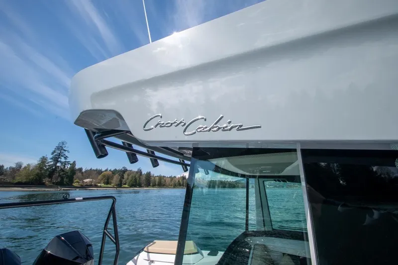 Slide: The Image of 2026 Axopar 29 XC Cross Cabin boat on serene water with clear sky. - 12