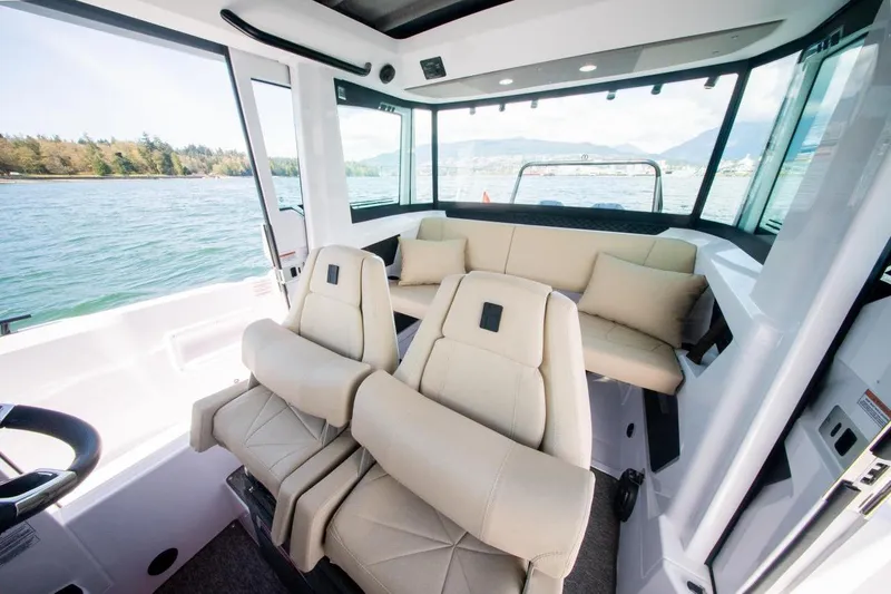 Slide: The Image of Interior of 2026 Axopar 29 XC Cross Cabin boat with luxurious seating and scenic water view. - 18