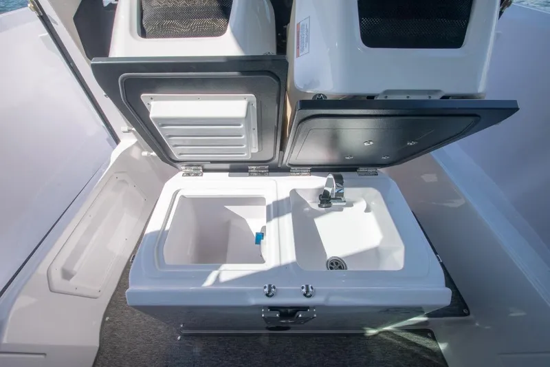 Slide: The Image of 2026 Axopar 29 XC Cross Cabin sink and storage area, featuring modern design and functionality. - 24