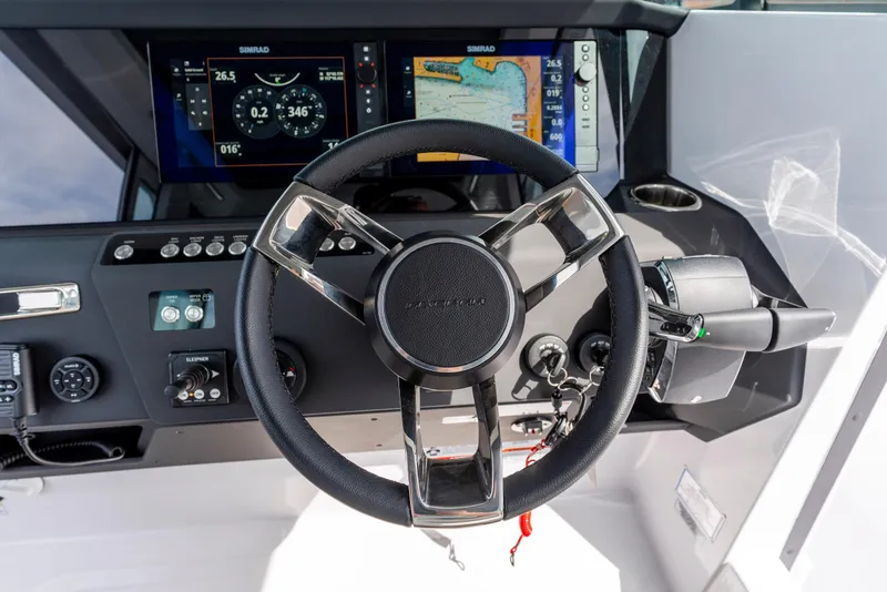 Slide: The Image of Steering wheel and dashboard of 2026 Axopar 29 XC Cross Cabin boat with navigation displays. - 22