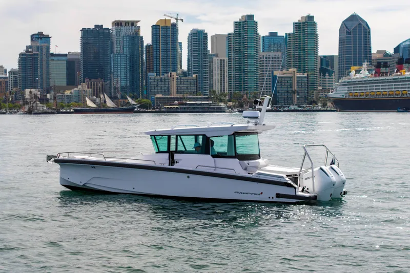 Slide: The Image of 2026 Axopar 29 XC Cross Cabin boat on water with city skyline backdrop. - 3