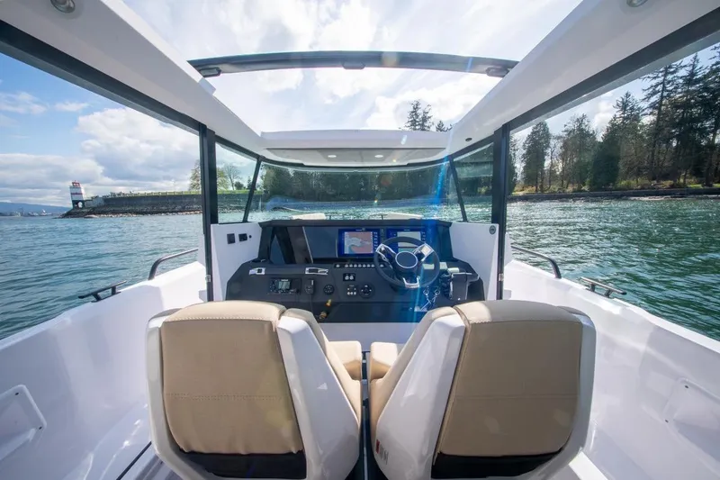 Slide: The Image of 2026 Axopar 29 XC Cross Cabin interior with scenic water view and lighthouse. - 16