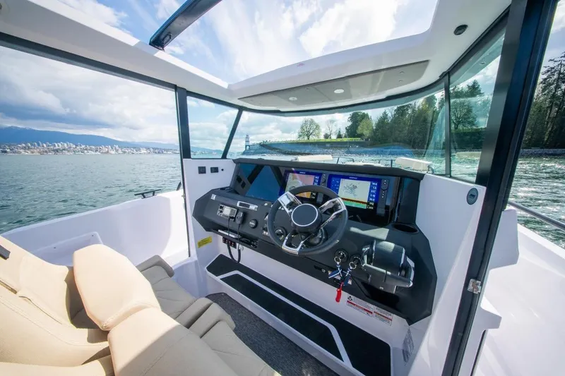 Slide: The Image of Interior view of 2026 Axopar 29 XC Cross Cabin boat with modern dashboard and scenic water backdrop. - 20