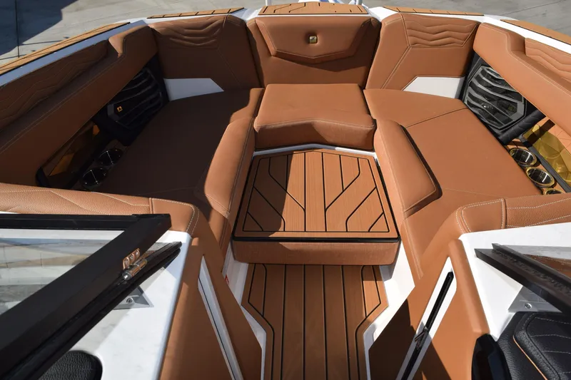 Slide: The Image of 2026 Nautique Super Air Nautique G23 boat interior with luxurious brown seating and wood accents. - 10