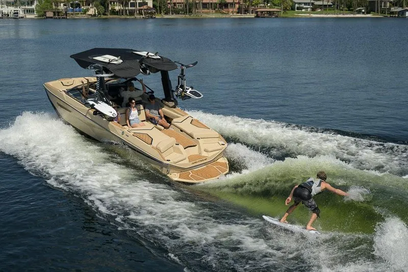 Slide: The Image of Manufacturer Provided Image: 2026 Nautique Super Air Nautique G23 towing a wakeboarder on a sunny lake. - 13