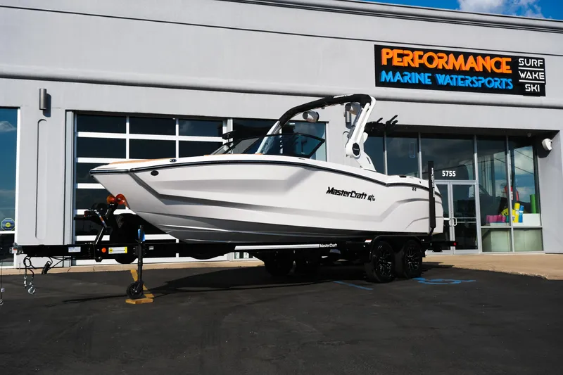 The Image of 2026 MasterCraft NXT23 boat on trailer at Performance Marine Watersports dealership. - 1