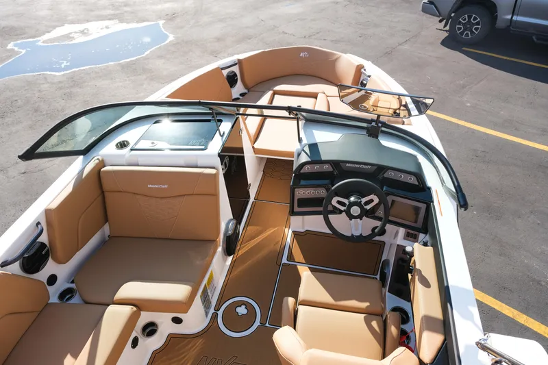 Slide: The Image of 2026 MasterCraft NXT23 boat interior with tan seating and modern dashboard design. - 11