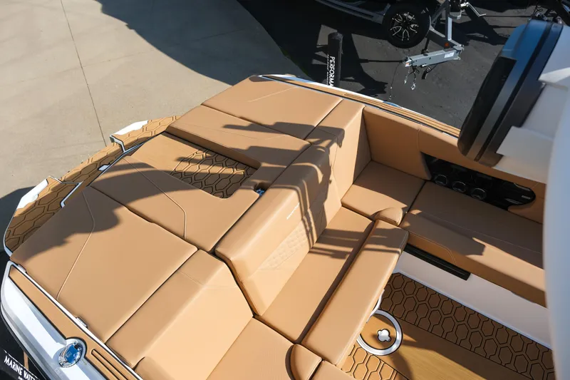 Slide: The Image of 2026 MasterCraft NXT23 boat interior with tan seating and hexagonal pattern flooring. - 12